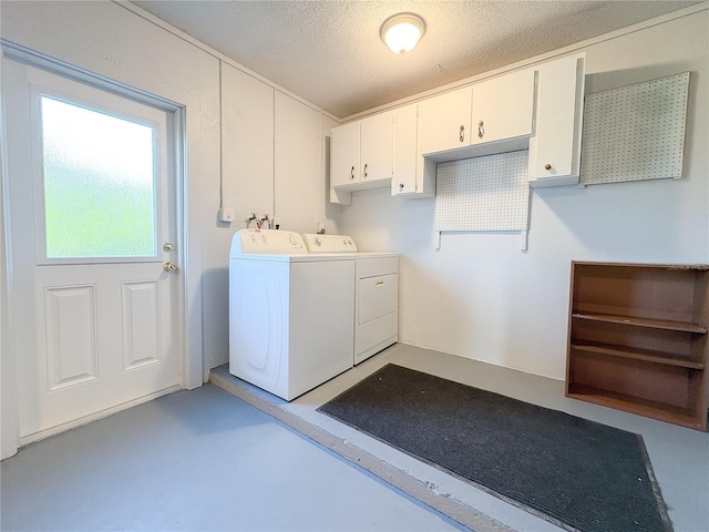 laundry room with cabinet space, washing machine and clothes dryer, and a textured ceiling