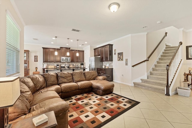 living room with visible vents, baseboards, stairway, light tile patterned flooring, and crown molding