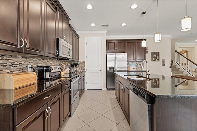 kitchen with dark brown cabinetry, stainless steel appliances, ornamental molding, a sink, and visible vents