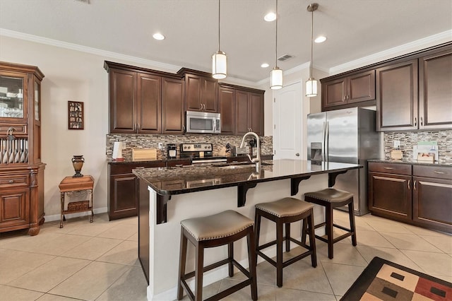 kitchen with light tile patterned floors, ornamental molding, appliances with stainless steel finishes, and a sink