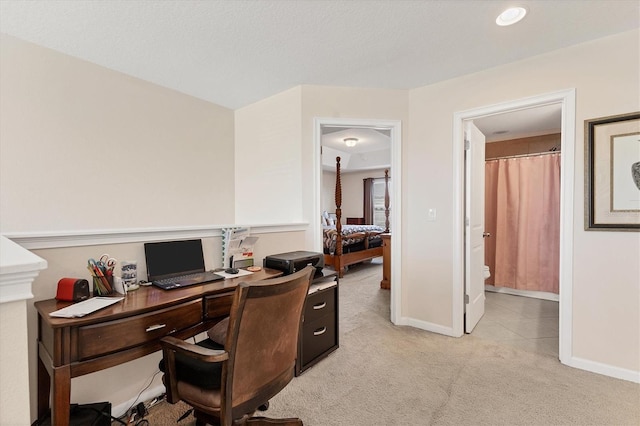 office space with baseboards and light carpet