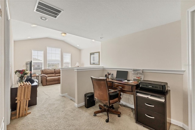 office space with light colored carpet, visible vents, vaulted ceiling, and baseboards