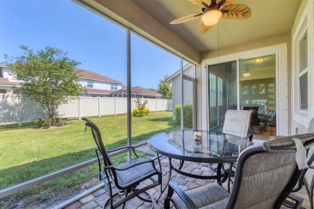 sunroom / solarium featuring outdoor dining space and a ceiling fan