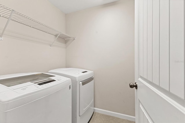 washroom featuring washer and clothes dryer, baseboards, and laundry area