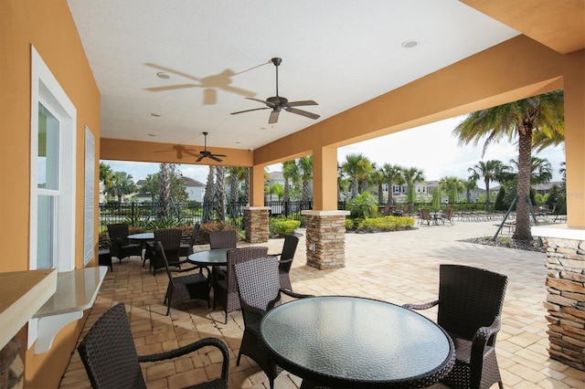 view of patio featuring fence, ceiling fan, and outdoor dining area