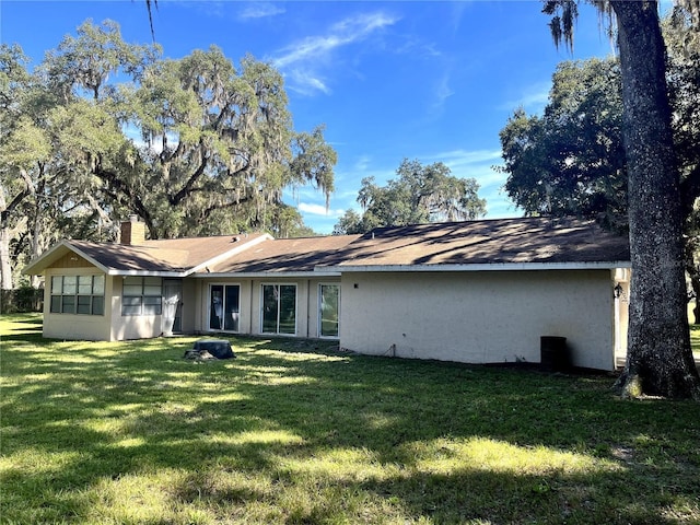 3 Lakeside Dr, Ocala, FL 34482 - rear view of house with a yard, a chimney, and roof with shingles