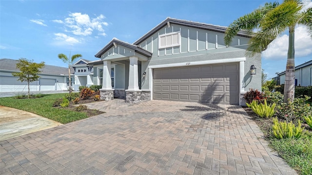 4725 Antrim Dr, Sarasota, FL 34240 - view of front facade with decorative driveway, stucco siding, an attached garage, board and batten siding, and stone siding