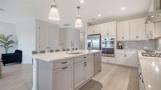 4725 Antrim Dr, Sarasota, FL 34240 - kitchen with a sink, appliances with stainless steel finishes, light wood-type flooring, an island with sink, and recessed lighting