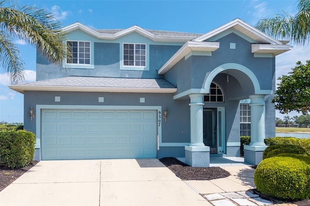view of front of property featuring concrete driveway, an attached garage, and stucco siding