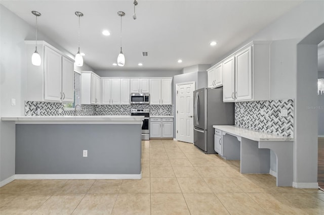 kitchen with white cabinets, light countertops, stainless steel appliances, a peninsula, and backsplash