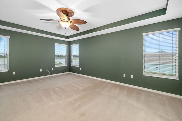 empty room featuring baseboards, carpet, and a tray ceiling