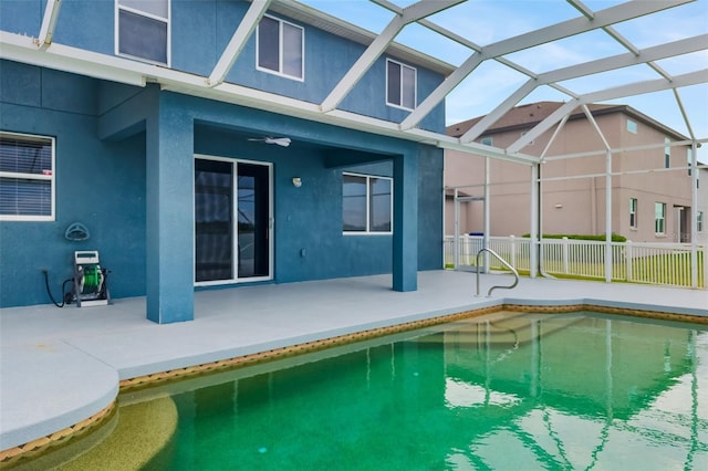 pool with fence, a lanai, and a patio area