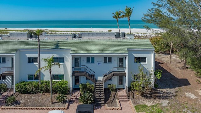 6951 Gulf Of Mexico Dr Unit 14, Longboat Key, FL 34228 - view of front of house featuring stucco siding, a view of the beach, stairway, a water view, and a tiled roof