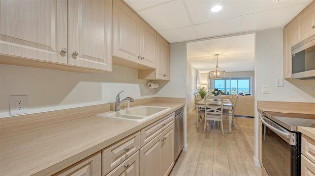 6951 Gulf Of Mexico Dr Unit 14, Longboat Key, FL 34228 - kitchen with stainless steel appliances, light wood finished floors, light countertops, and a sink