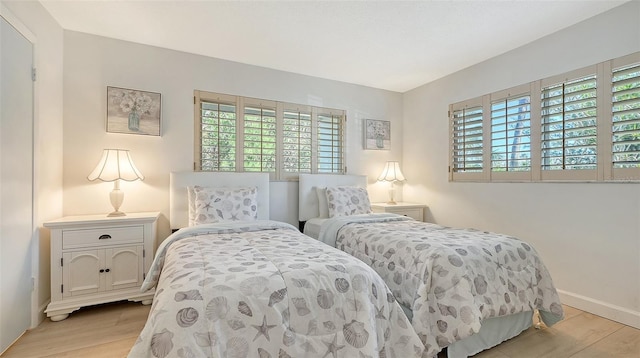 6951 Gulf Of Mexico Dr Unit 14, Longboat Key, FL 34228 - bedroom featuring baseboards, multiple windows, and wood finished floors