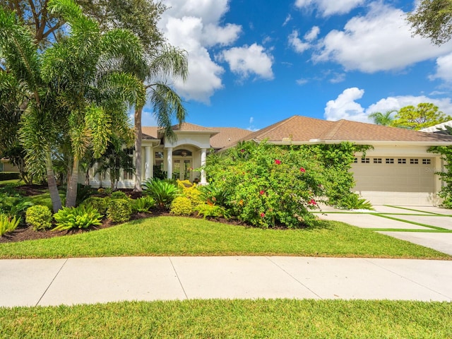 8687 Woodbriar Dr, Sarasota, FL 34238 - view of front of property featuring a garage, stucco siding, concrete driveway, and a front yard