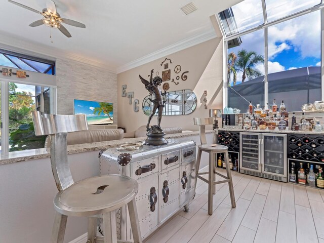 8687 Woodbriar Dr, Sarasota, FL 34238 - kitchen with wine cooler, a ceiling fan, ornamental molding, white cabinets, and light countertops