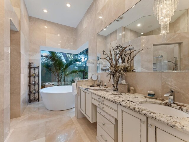 8687 Woodbriar Dr, Sarasota, FL 34238 - full bath featuring tile walls, marble tiled flooring, double vanity, a freestanding tub, and a walk in shower
