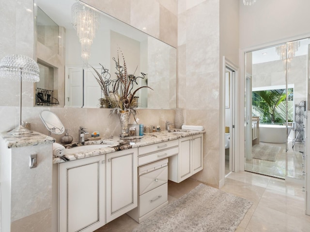 8687 Woodbriar Dr, Sarasota, FL 34238 - bathroom featuring double vanity, a freestanding bath, a chandelier, toilet, and backsplash