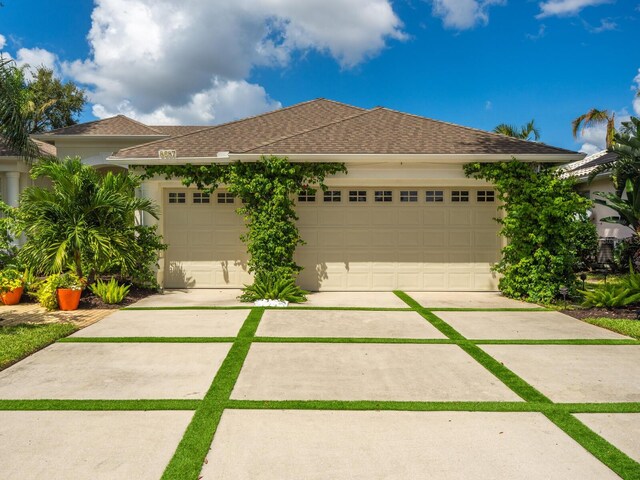 8687 Woodbriar Dr, Sarasota, FL 34238 - ranch-style house with driveway, a garage, a shingled roof, and stucco siding