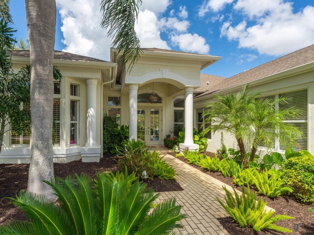 8687 Woodbriar Dr, Sarasota, FL 34238 - view of exterior entry with french doors and stucco siding