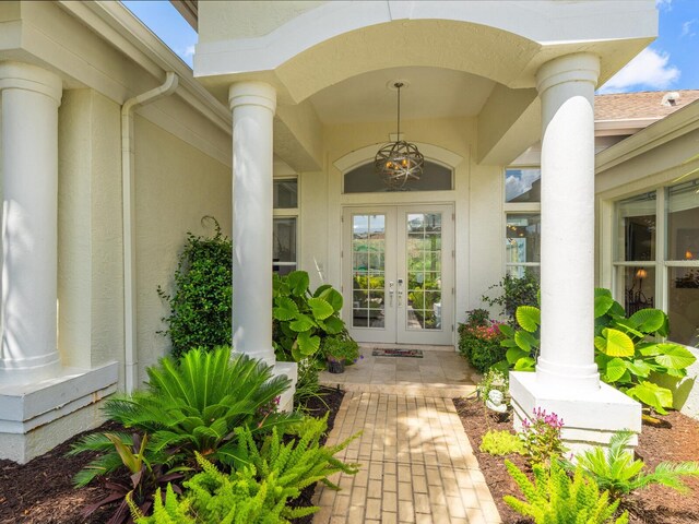 8687 Woodbriar Dr, Sarasota, FL 34238 - view of exterior entry with french doors, stucco siding, and covered porch
