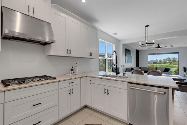 8355 Velda Trl, Sarasota, FL 34241 - kitchen with appliances with stainless steel finishes, under cabinet range hood, a peninsula, light tile patterned floors, and white cabinets