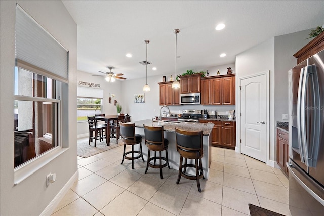 kitchen with a sink, recessed lighting, a breakfast bar, and stainless steel appliances