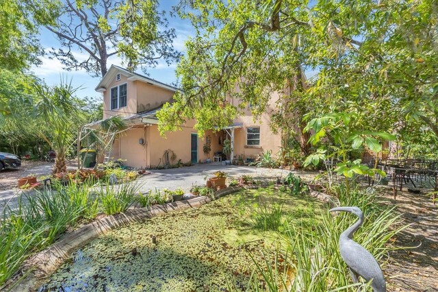 rear view of house featuring a patio and stucco siding