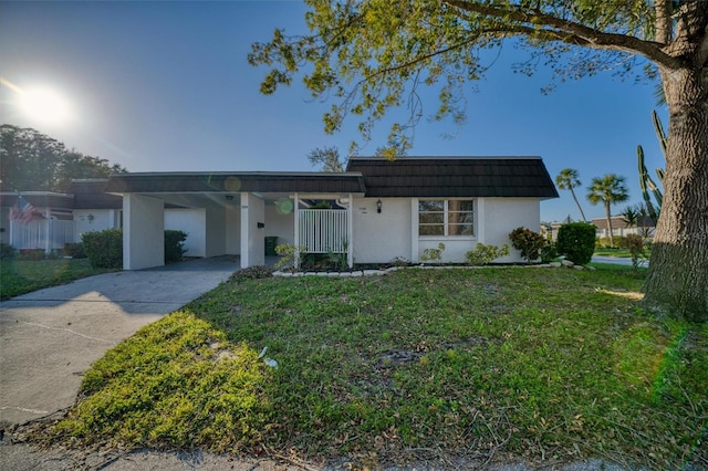 mid-century inspired home featuring mansard roof, stucco siding, a carport, a front lawn, and concrete driveway