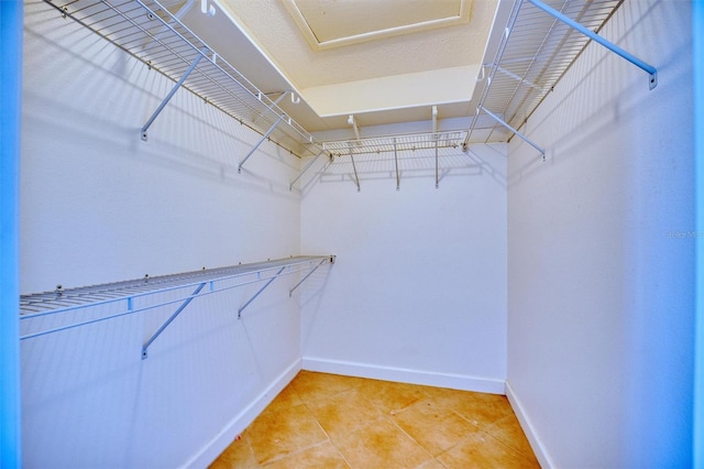 spacious closet with light tile patterned floors
