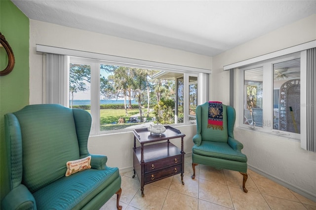sitting room with baseboards, a healthy amount of sunlight, and tile patterned floors