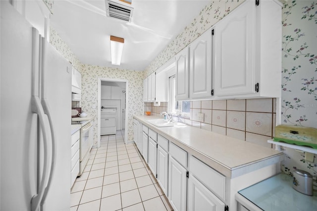 kitchen featuring visible vents, wallpapered walls, a sink, and white appliances
