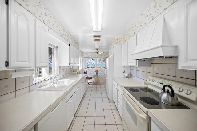 kitchen featuring a sink, visible vents, custom exhaust hood, wallpapered walls, and white appliances