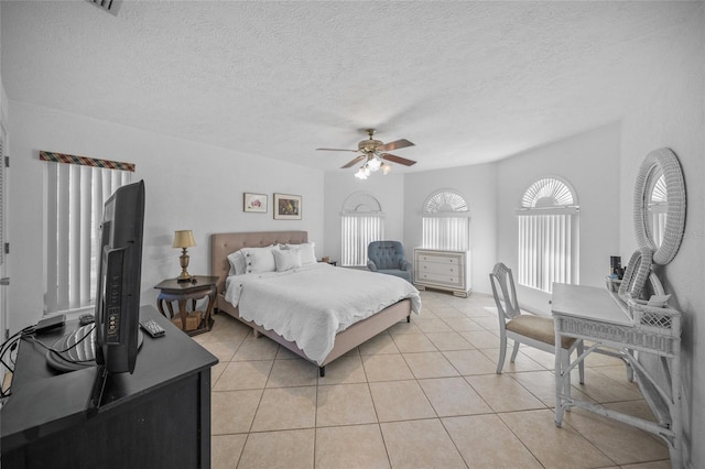 bedroom featuring a textured ceiling, a ceiling fan, and light tile patterned floors