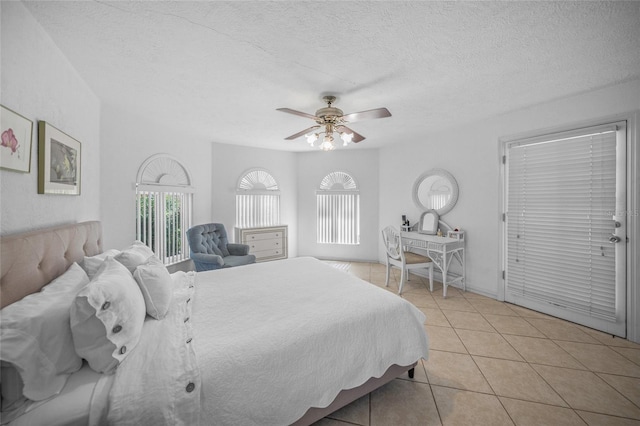 bedroom with a textured ceiling, a ceiling fan, and light tile patterned floors