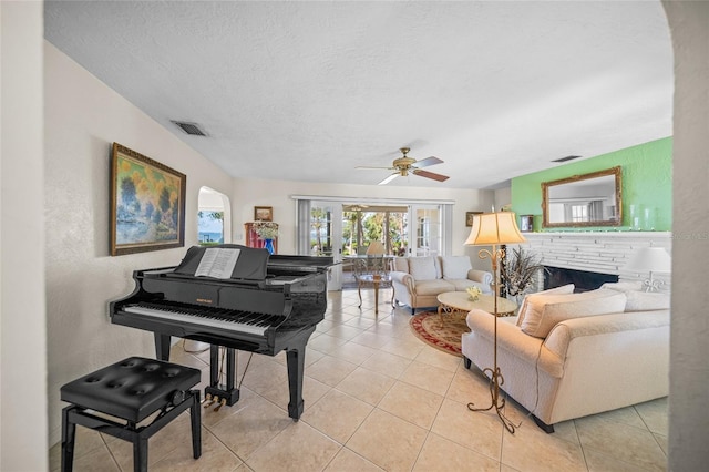 living area featuring visible vents, a textured ceiling, ceiling fan, and light tile patterned flooring