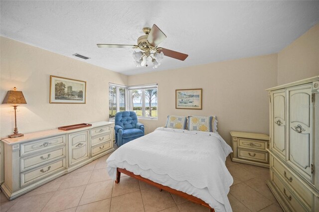 bedroom with ceiling fan, visible vents, and light tile patterned floors