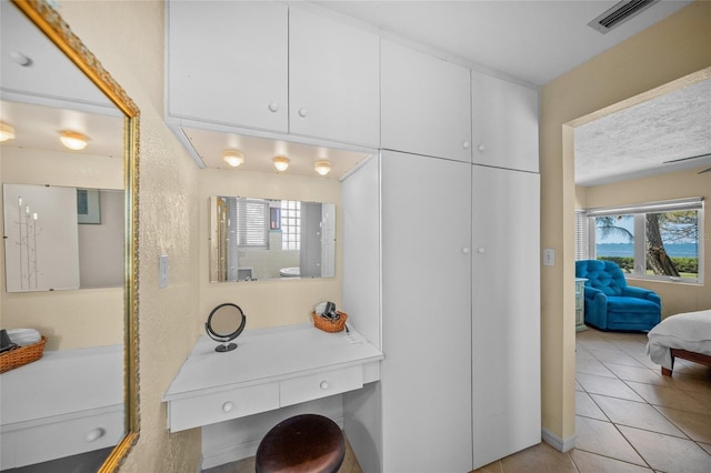 ensuite bathroom featuring plenty of natural light, ensuite bathroom, visible vents, and tile patterned floors