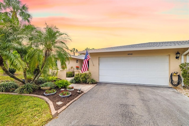 6940 W Country Club Dr N Unit V-77, Sarasota, FL 34243 - view of front of home featuring driveway, stucco siding, and an attached garage