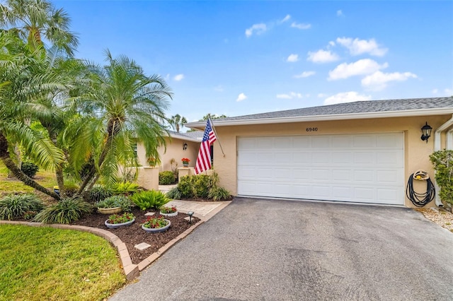 6940 W Country Club Dr N Unit V-77, Sarasota, FL 34243 - view of front of property with an attached garage, driveway, and stucco siding
