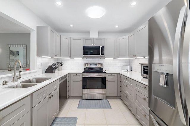 6940 W Country Club Dr N Unit V-77, Sarasota, FL 34243 - kitchen with light tile patterned floors, gray cabinets, a sink, stainless steel appliances, and decorative backsplash
