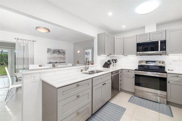 6940 W Country Club Dr N Unit V-77, Sarasota, FL 34243 - kitchen with gray cabinets, a sink, backsplash, and appliances with stainless steel finishes
