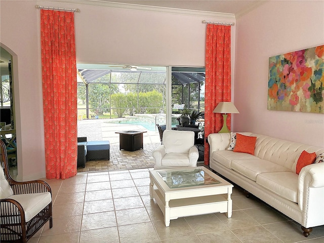living room with a sunroom, crown molding, arched walkways, and light tile patterned floors