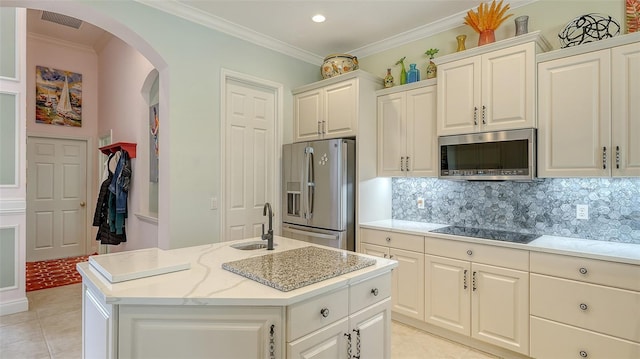 kitchen featuring stainless steel appliances, arched walkways, a sink, light tile patterned floors, and ornamental molding