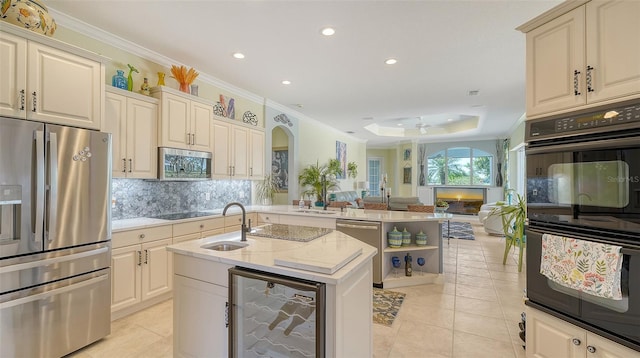 kitchen featuring black appliances, wine cooler, a sink, decorative backsplash, and ornamental molding
