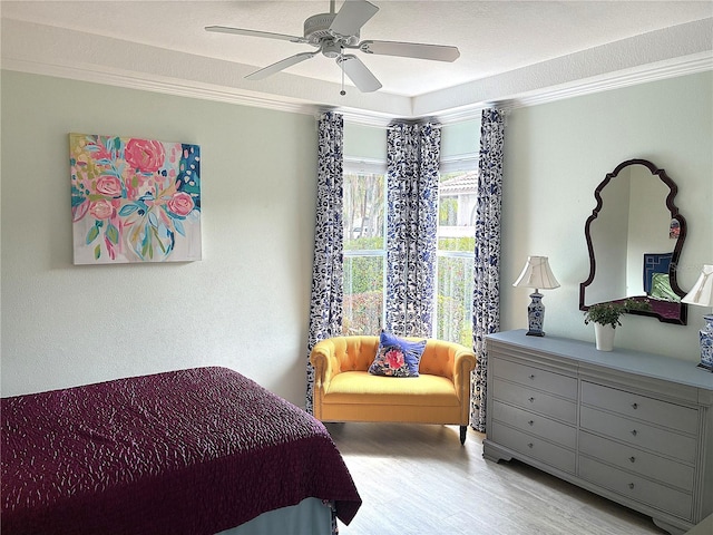 bedroom featuring crown molding, wood finished floors, and a ceiling fan