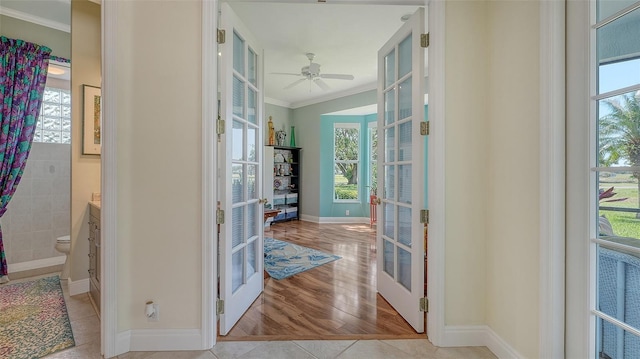 entryway featuring ornamental molding, healthy amount of natural light, french doors, and baseboards