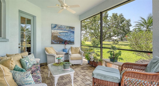 sunroom with ceiling fan and an outdoor living space