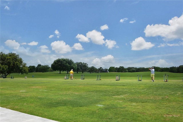 view of property's community featuring a yard and view of golf course